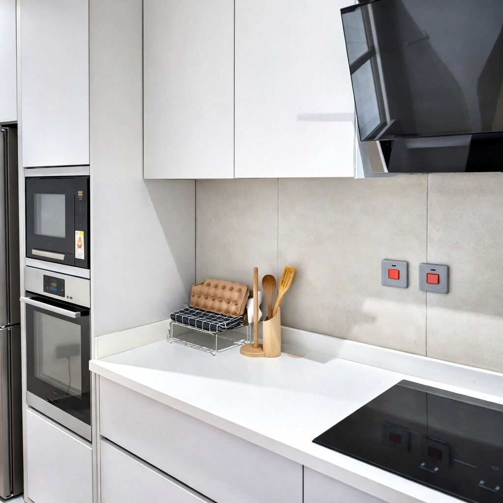 Eine moderne Küche mit integrierten Geräten, einer Mikrowelle, einem Backofen und einer schwarzen Induktionskochplatte.