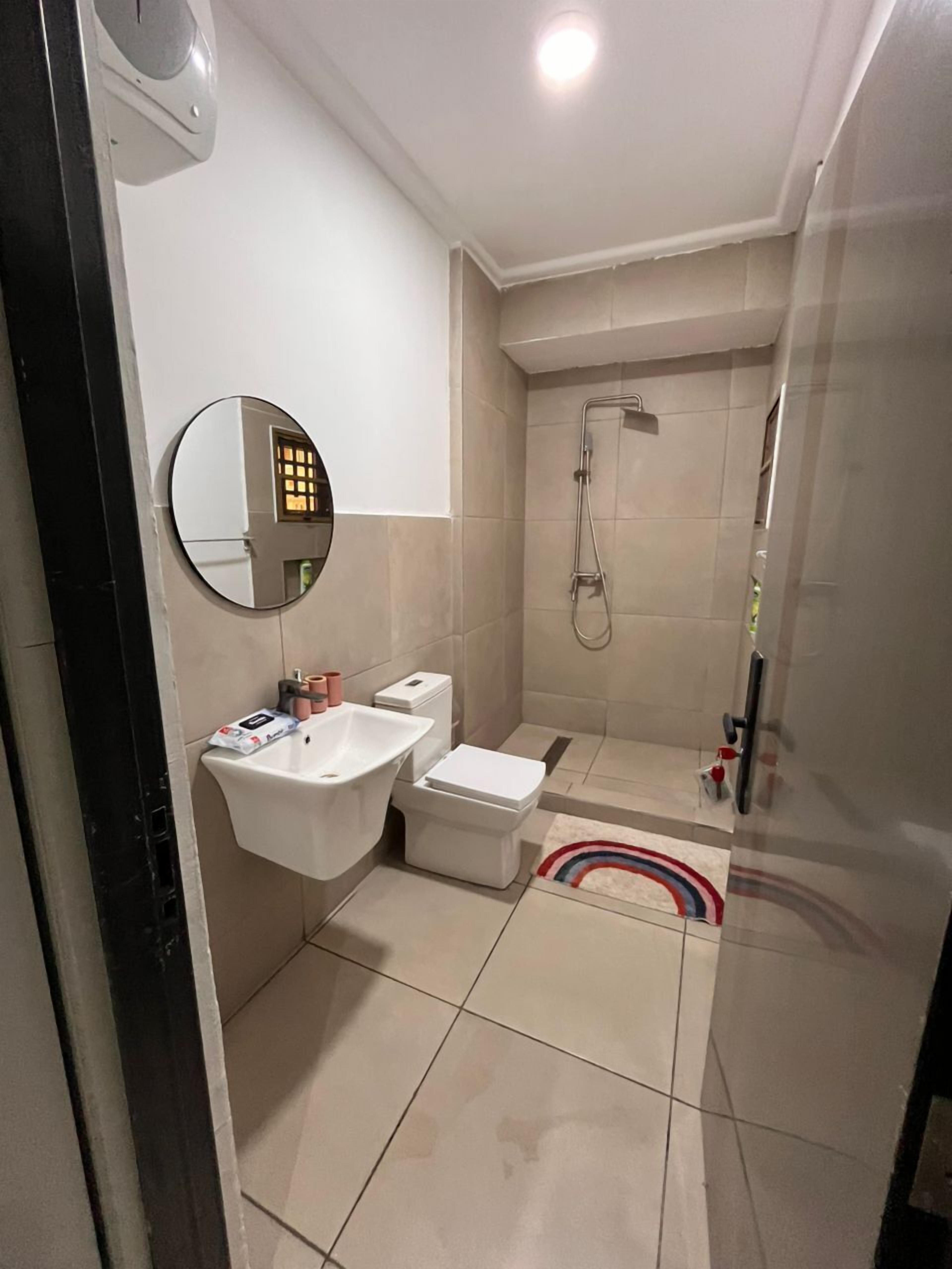 Un baño moderno con lavamanos, inodoro y ducha.