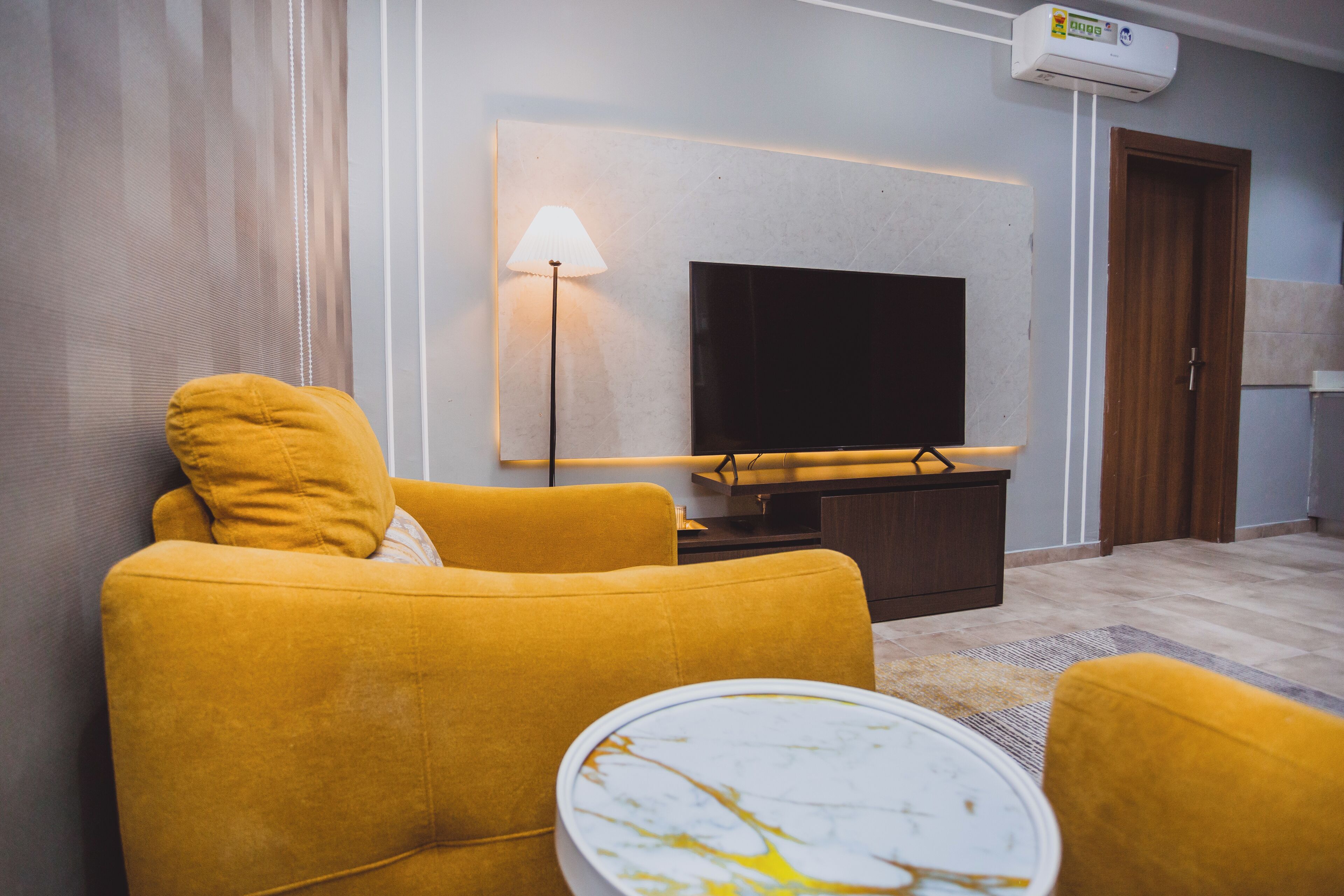 A living room with a sofa, a coffee table, a flat-screen TV, and a lamp.