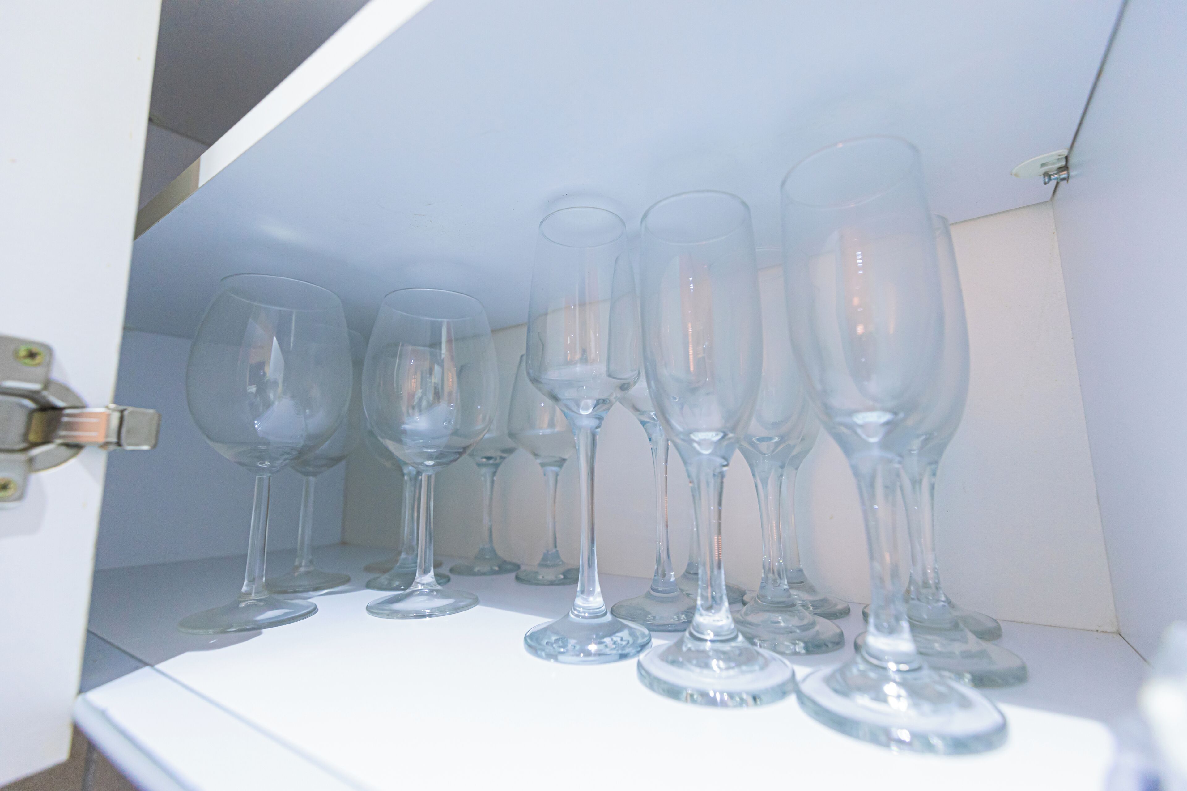Une étagère avec plusieurs verres à vin transparents.