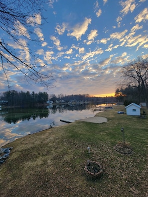 A lakeside property with a dock, a small shed, and a grassy area.