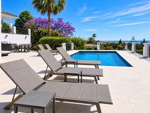 A poolside area with lounge chairs, a pool, and a view of the ocean. - Villa with private pool & casita + sea views (Mijas Costa)