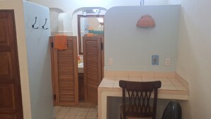 Un baño con puertas de madera, un espejo, un perchero y un lavabo.