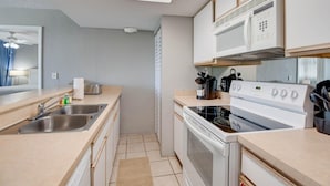 A compact kitchen with a sink, stove, microwave, and cabinets. - The Barbados | Private Balcony, Pool View! (Key West)