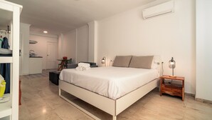 Quarto moderno com cama, mesas de cabeceira e guarda-roupa.