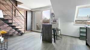 Una cocina moderna con un ventanal grande, estufa integrada y un comedor con mesa y sillas.