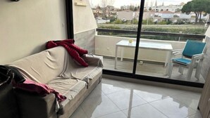 Un balcon avec un canapé, une table et des chaises.