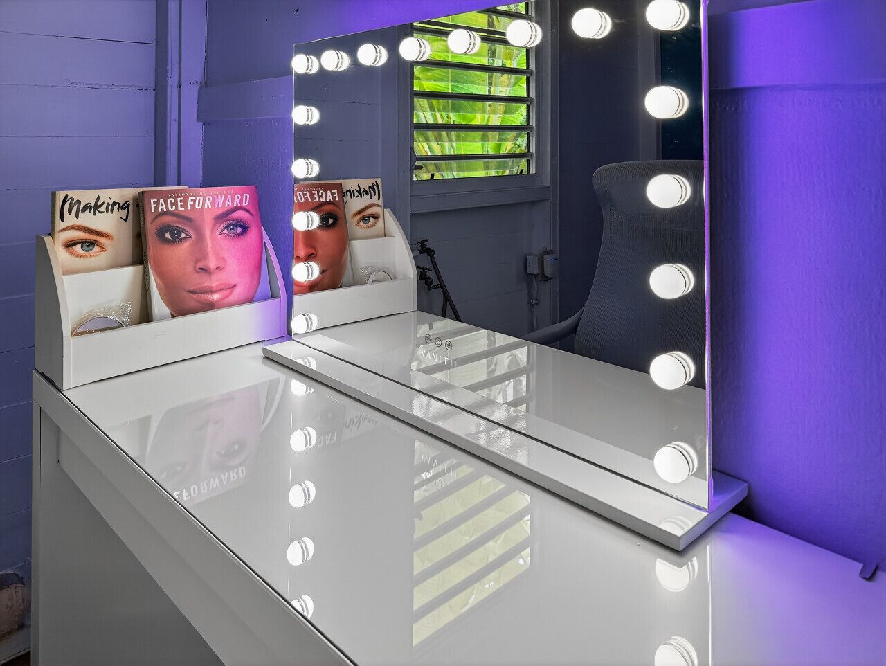 Une coiffeuse avec un miroir et des lampes, une fenêtre avec des stores et une chaise.
