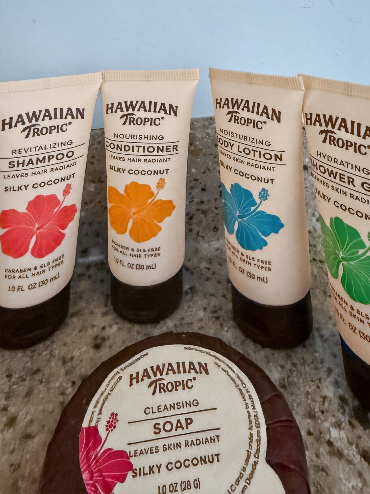 Four bottles of Hawaiian Tropic hair care products and one bar of cleansing soap.
