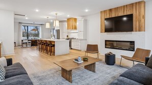 A modern living room with a sofa, a coffee table, and a fireplace. - NEW Modern Nashville Escape with Rooftop Hot Tub (Nashville)