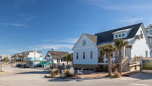 A coastal street with white houses, palm trees, and a clear blue sky. - Molly's Beachside Cottage 3BR 2BA Almost Oceanfront in Atlantic Beach (Atlantic Beach)