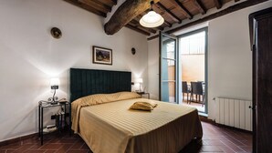 Una camera da letto con un letto, abat-jour, un quadro appeso e vista del balcone.