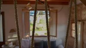 Una stanza con un divano, un tavolo e una corda sospesa.