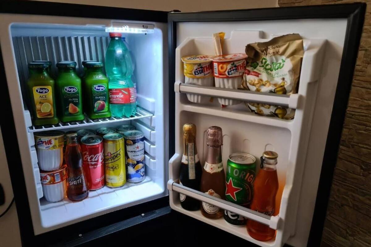 An open refrigerator with various beverages and snacks.