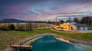 Una casa con una veranda spaziosa, una piscina e un garage.