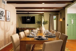 Een eethoek met een houten tafel voor zes personen, omringd door zes stoelen.