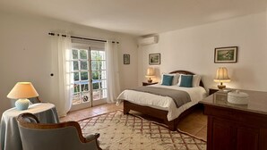 A bedroom with a bed, two bedside tables with lamps, a chair, a dresser, and a window with curtains. - Palmeiral | Private Pool | 10 Pax | Pêra (Pêra)