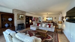 A living room with a fireplace, a sofa set, a coffee table, and a TV. - Palmeiral | Private Pool | 10 Pax | Pêra (Pêra)