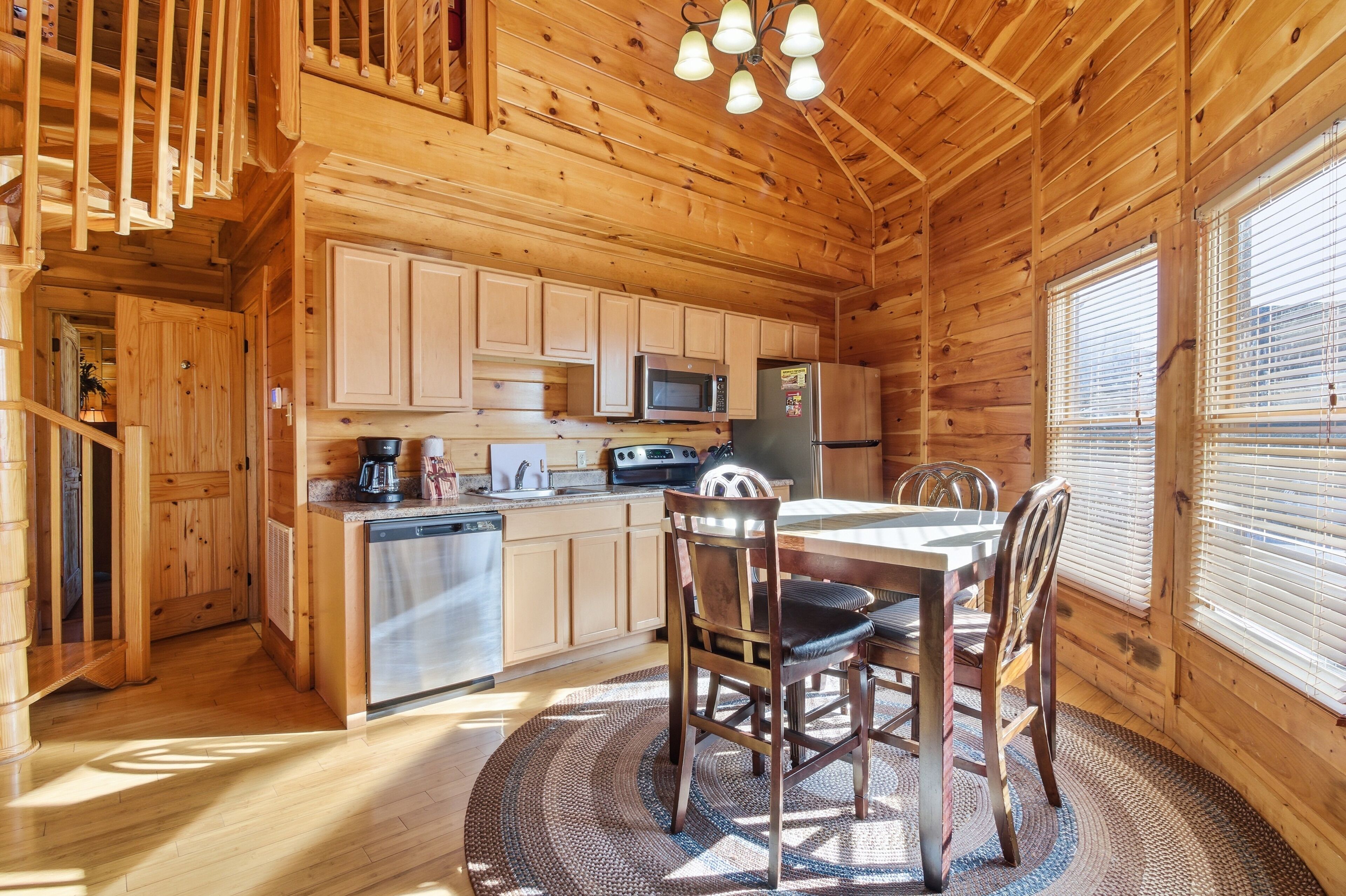 Ein Holzblock-Interieur mit Küche, Essbereich und einer Treppe.
