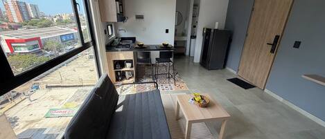 Un apartamento moderno con kitchenette, comedor y sofá.