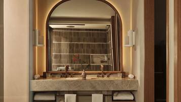 A bathroom with a large mirror, a marble sink, and a towel rack.