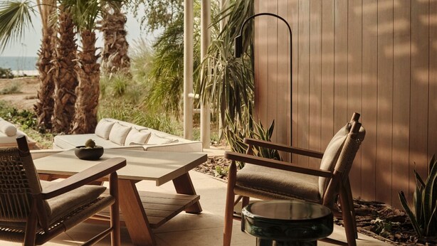 An outdoor patio with a sofa, chairs, a table, and a lamp. - Rosewood AMAALA (Al Wajh)