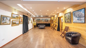A spacious hallway with a fireplace, wooden walls, and artwork on the walls. - Hotel Liad (Bucharest)