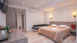 A modern hotel room with a bed, bedside table, and a TV mounted on the wall. - Hotel Liad (Bucharest)