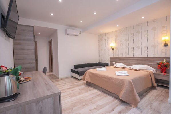 A modern hotel room with a bed, bedside table, and a TV mounted on the wall. - Hotel Liad (Bucharest)