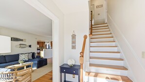 Una escalera de madera con barandilla que lleva a un piso superior.