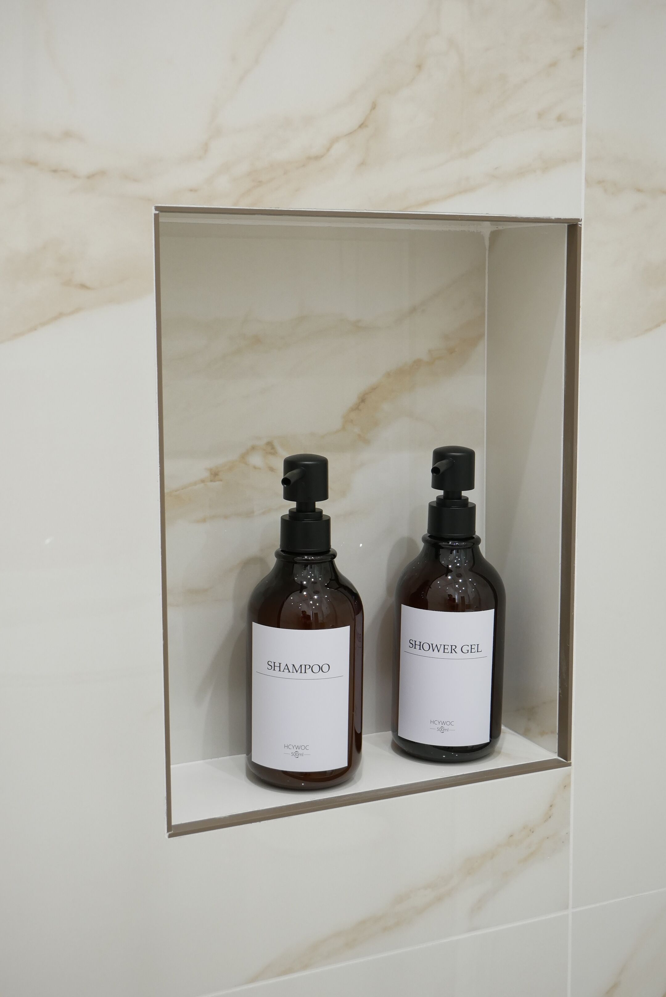 Zwei Flaschen Shampoo und Duschgel in einem Badezimmerschrank.