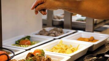 A buffet with various food items in containers.