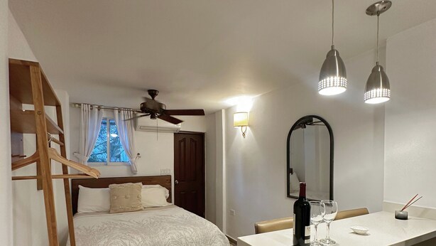 A bedroom with a bed, a wooden ladder, a desk with a chair, and a mirror. - Charming Studio Apartment in Prado Santa Marta 3. (Santa Marta)