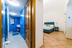 A modern bathroom with blue tiles, a sink, and a shower. - Room 'Amalfi Luxury Rooms' with Balcony, Wi-Fi and Air Conditioning (Meta)