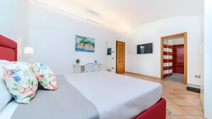A modern hotel room with a bed, desk, chair, and a TV mounted on the wall. - Room 'Sorrento Luxury' with Wi-Fi and Air Conditioning (Meta)