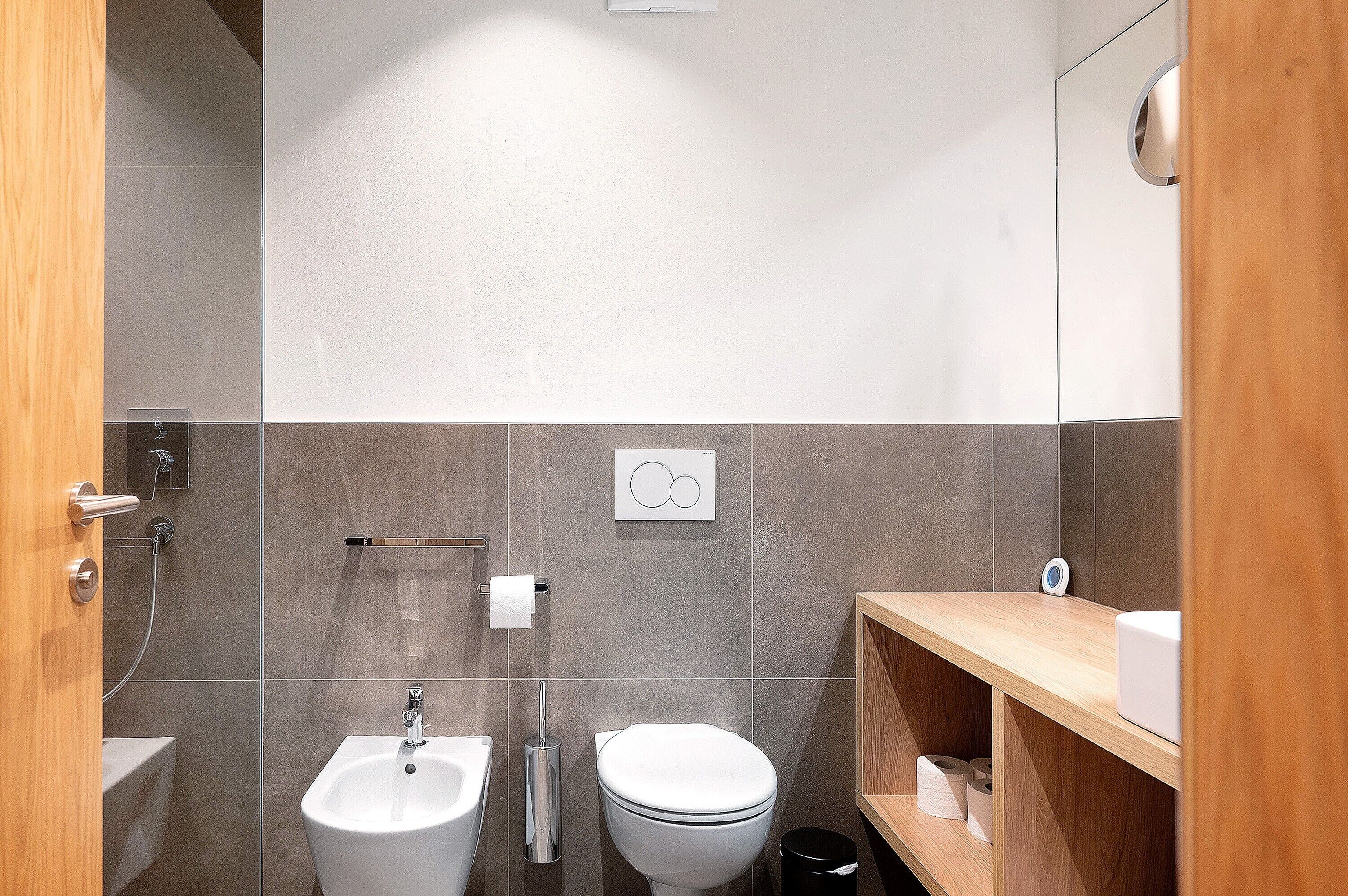 A modern bathroom with a toilet, bidet, and sink.