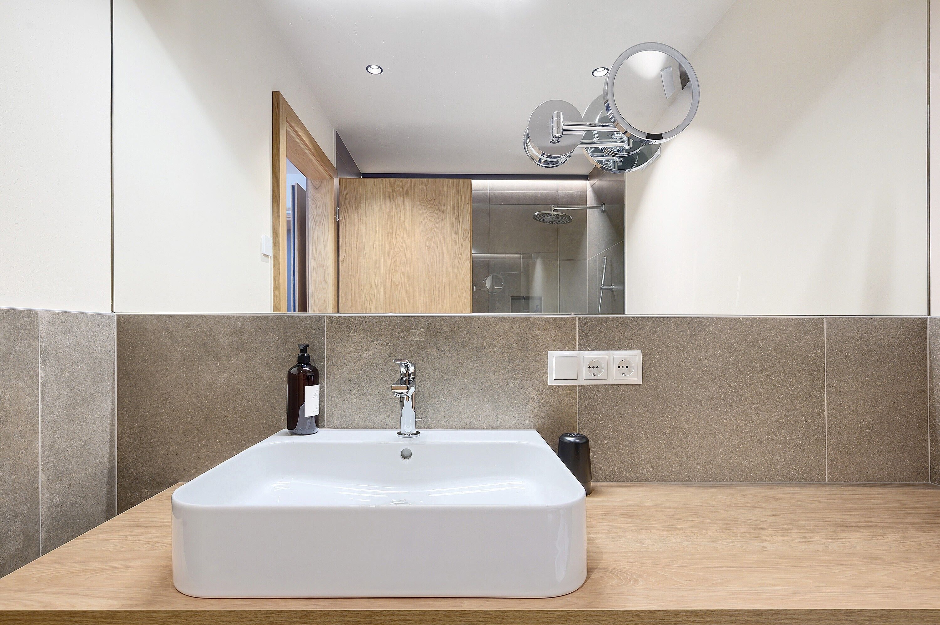 Ein Badezimmer mit Waschbecken, Spiegel und Dusche.