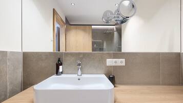 Ein Badezimmer mit Waschbecken, Spiegel und Dusche.