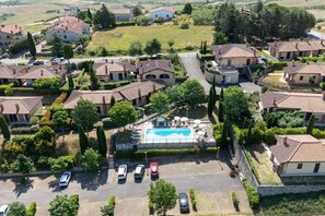 Área residencial com casas, piscina e carros estacionados.