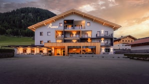 A modern hotel with a two-story structure, balconies, and a restaurant area.
