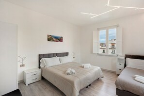 A modern bedroom with a large bed, bedside tables, a window with a view, and a painting on the wall. - Apartment 'Sorrento Center Luxury  3' with Balcony, Wi-Fi and Air Conditioning (Sorrento)