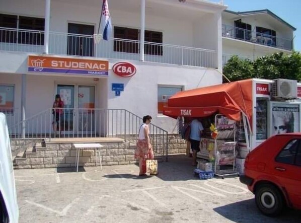 Un bâtiment dont la devanture porte les inscriptions « STUDENAC MARKET » et « CBA ».