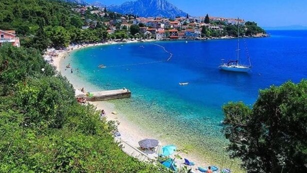 A coastal town with a beach, boats, and a mountain in the background. - Apartments Filip & Miroslav (Gradac)