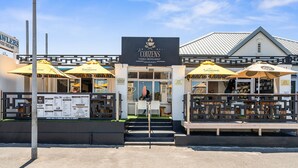 Un restaurant familial appelé « Cousens », doté d’une terrasse et d’un panneau affichant le menu.