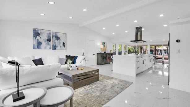 A modern living room with a white sofa, coffee table, and artwork on the wall. - Waterfront 4BR Retreat w/HotTub Dock & Outdoor Bar (Fort Lauderdale)