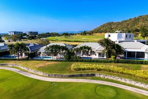 A golf course with a clubhouse, a swimming pool, and a white building with a 'For Sale' sign. - Pool Villa Black Mountain Hua Hin BM30 (Hua Hin)