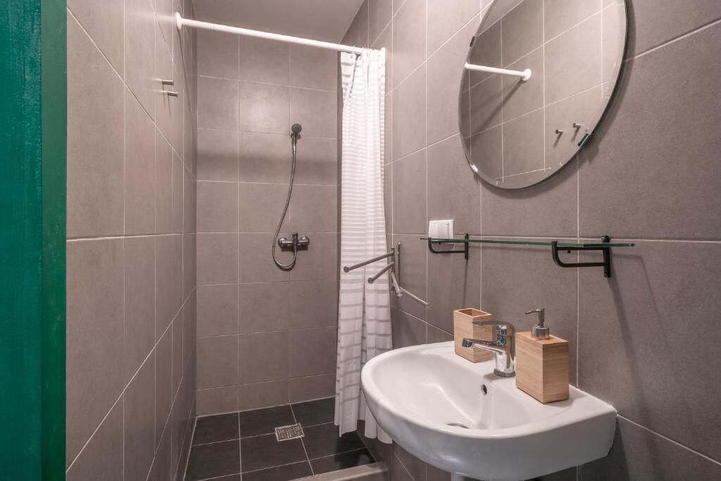 Familiekamer, uitzicht op binnenplaats | Badkamer | Een douche, een haardroger, toiletpapier