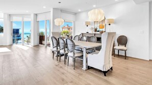 Un comedor amplio con una gran mesa y sillas, un candelabro y vistas al exterior.