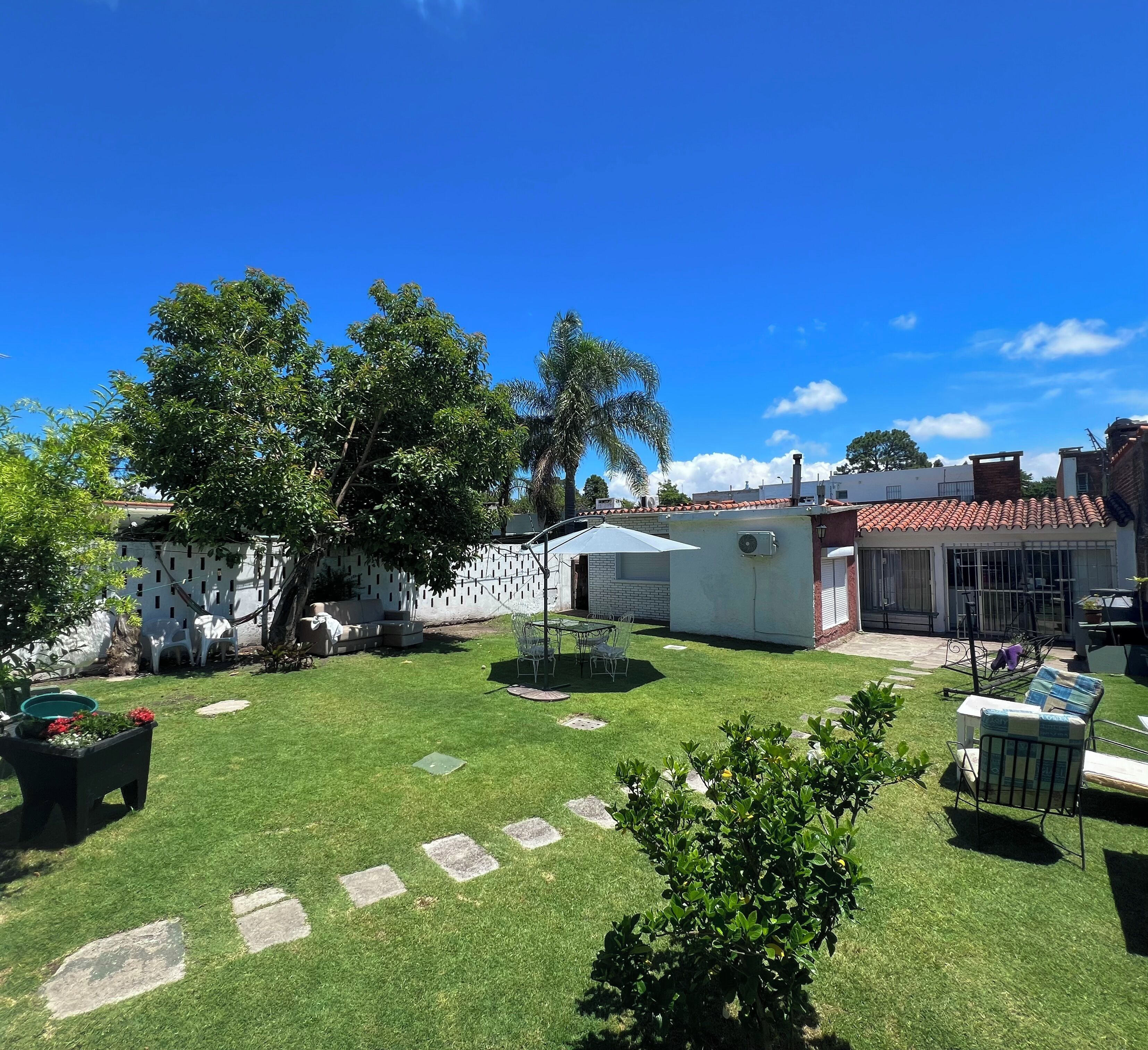 A well-maintained backyard with a lawn, outdoor furniture, and a small garden area.