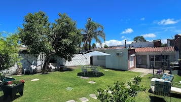 A well-maintained backyard with a lawn, outdoor furniture, and a small garden area.